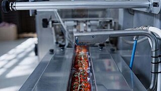 The picture shows packaging production for tomatoes