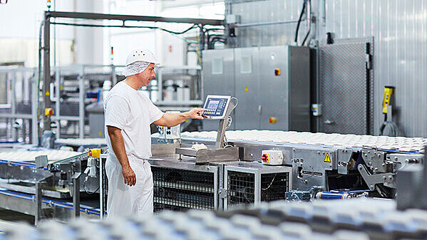 a man at a production site who operates a weight indicator Combics® 2 Ex (CAIXS2)