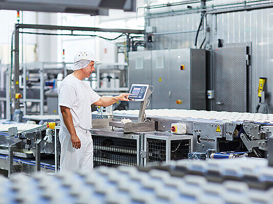 a man at a production site who operates a weight indicator Combics® 2 Ex (CAIXS2)