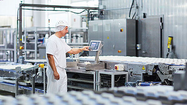 a man at a production site who operates a weight indicator Combics® 2 Ex (CAIXS2)