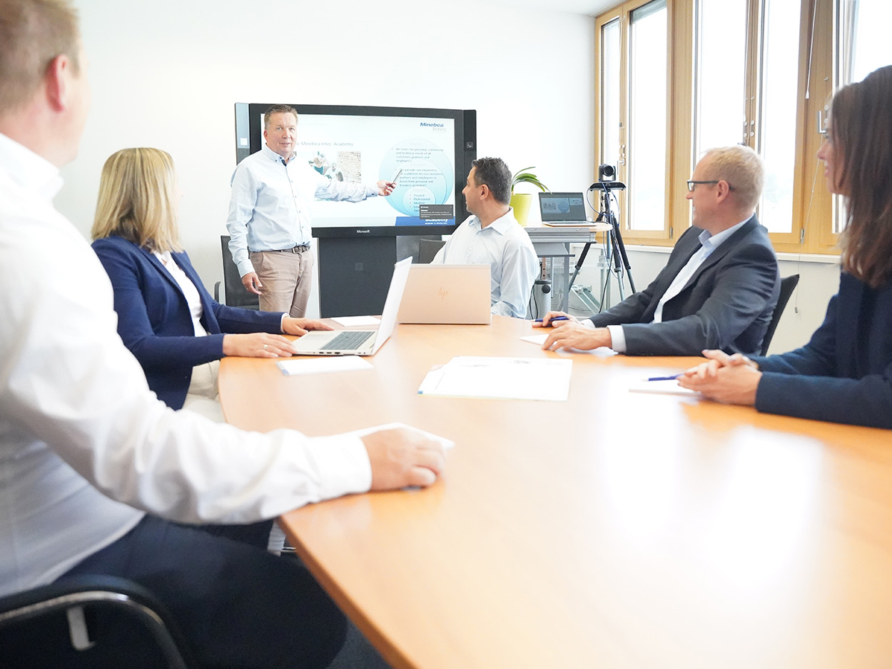 A group of minebea intec employees in a meeting