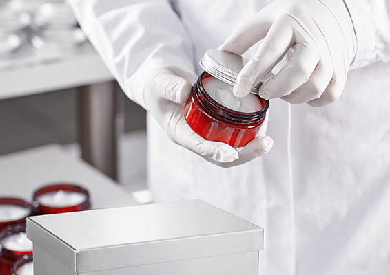 Picture showing a worker filling container with cream cosmetic using a signum scale