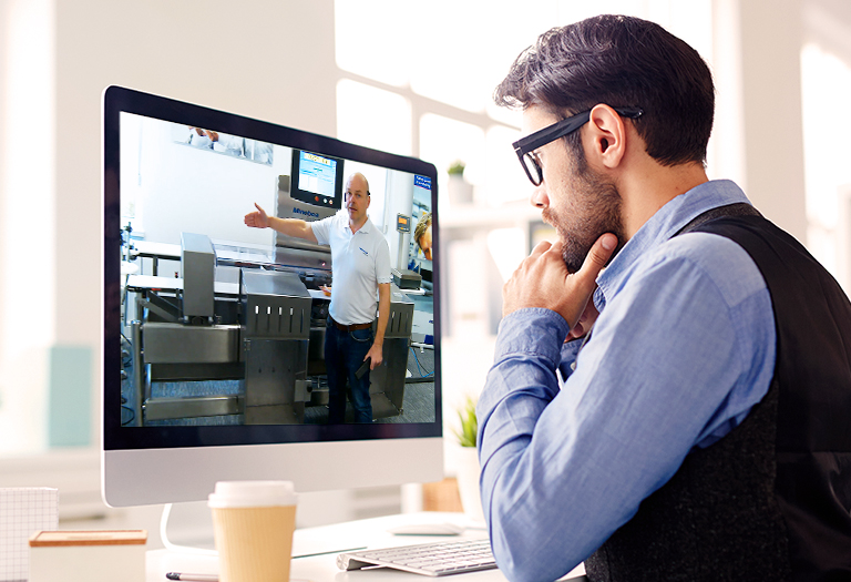 Man sitting in front of a computer, attending a virtual guided tour