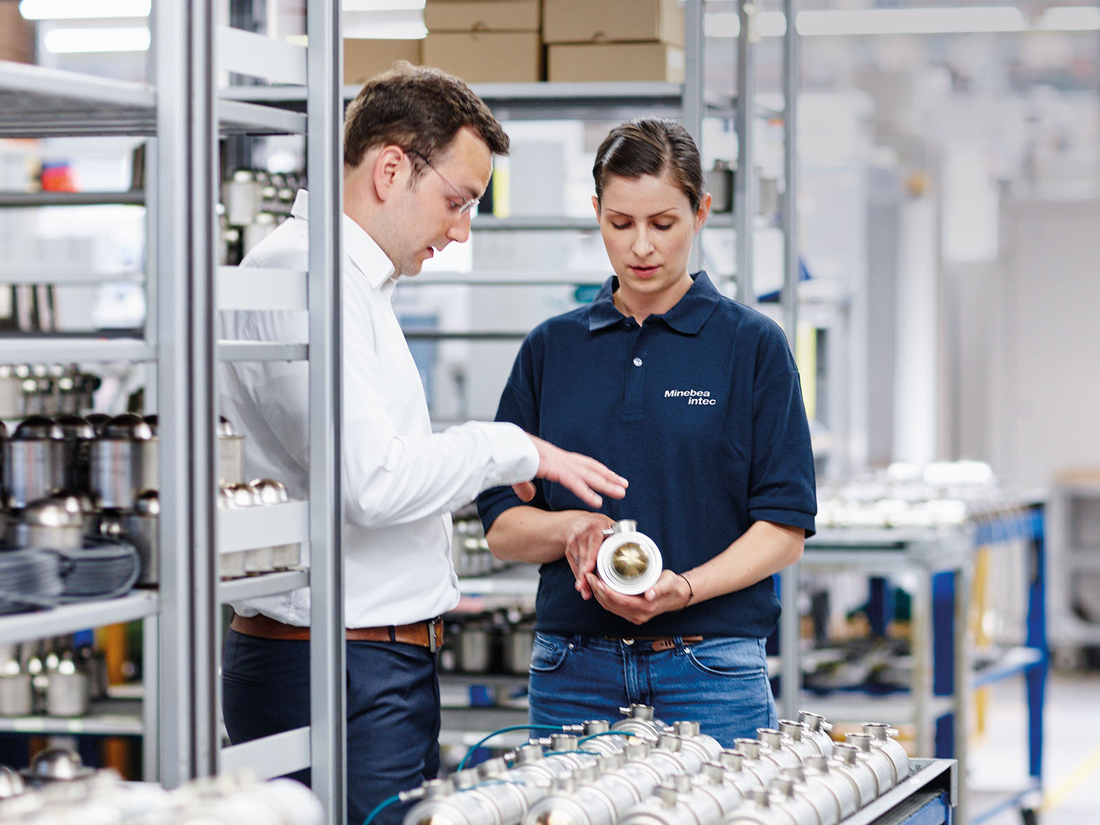 A man and a woman looking talking over a technical component